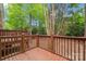 Spacious wooden deck with brown railings overlooking a lush backyard with mature trees at 1126 Dean Hall Ln, Matthews, NC 28105