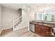 Modern kitchen featuring granite countertops, stainless steel appliances, and staircase with backyard views at 1126 Dean Hall Ln, Matthews, NC 28105