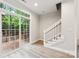 Sunlit living room with hardwood floors, glass sliding door that leads to a wooden deck and staircase at 1126 Dean Hall Ln, Matthews, NC 28105