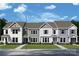 Charming townhome with a welcoming facade, showcasing various color schemes and architectural details against a bright blue sky at 11457 Prosperity Church Rd, Huntersville, NC 28078