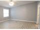A spacious bedroom is illuminated by natural light and features modern gray flooring at 1184 Sherwood Rd, Clover, SC 29710