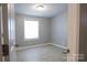 A well-lit bedroom with gray flooring and trim, and a large window with blinds at 1184 Sherwood Rd, Clover, SC 29710