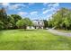 Farmhouse-style home surrounded by trees and a well-maintained grassy lot at 12504 Culp Rd, Gold Hill, NC 28071