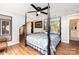 Stylish main bedroom with unique four-poster bed, hardwood floors, and natural light at 12504 Culp Rd, Gold Hill, NC 28071