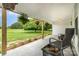 Charming covered porch with hanging plants, concrete flooring, a black wicker chair, and a serene view of the yard at 12504 Culp Rd, Gold Hill, NC 28071