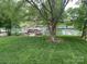 Backyard view features a green lawn, mature trees, and a waterfront area with docks and boats at 132 Marina Ln, Mooresville, NC 28117