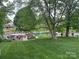 Lush green backyard overlooking lake with docks and boats, shaded by mature trees at 132 Marina Ln, Mooresville, NC 28117