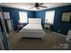 Bright bedroom with a blue accent wall, large windows, and neutral carpet at 132 Marina Ln, Mooresville, NC 28117