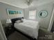 Well-lit bedroom with ceiling fan, large window, and beach-themed decor at 132 Marina Ln, Mooresville, NC 28117