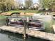 View of a boat lift with a modern pontoon boat on the water at 132 Marina Ln, Mooresville, NC 28117