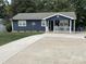 Charming single-story home featuring blue siding, a concrete driveway, and a welcoming front porch with rocking chairs at 132 Marina Ln, Mooresville, NC 28117