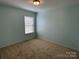 This bedroom includes a large window with window blinds and light blue walls at 14413 Lake Crossing Dr, Charlotte, NC 28278