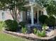 Inviting front porch with seating and a stone-bordered flower bed at 14413 Lake Crossing Dr, Charlotte, NC 28278