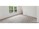 Light-filled bedroom with plush carpeting and a view of lush greenery through large windows at 148 Tangle River Dr # 67, Statesville, NC 28677