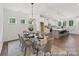 Open-concept dining area featuring a glass table, stylish chairs, and a modern chandelier at 148 Tangle River Dr # 67, Statesville, NC 28677