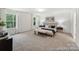 Large primary bedroom with plush carpeting, two windows, and stylish bedside tables at 148 Tangle River Dr # 67, Statesville, NC 28677