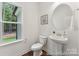 Stylish powder room with a pedestal sink, round mirror, and natural light from the window at 148 Tangle River Dr # 67, Statesville, NC 28677