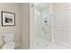Bright bathroom with sleek toilet, glass-enclosed shower, convenient seating, and built-in shelves for bath products at 1645 Carolina Cir, Gastonia, NC 28054