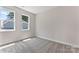 Empty bedroom with neutral paint, plush carpeting, and bright windows offering exterior views at 1645 Carolina Cir, Gastonia, NC 28054