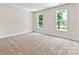 Spacious bedroom with plush carpeting, neutral paint, and a pair of bright windows overlooking the exterior at 1645 Carolina Cir, Gastonia, NC 28054