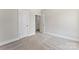 Bedroom with neutral carpeting and paint adjacent to an open doorway leading to a Jack and Jill bathroom at 1645 Carolina Cir, Gastonia, NC 28054