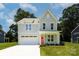 Charming two-story home with a light gray exterior, a red front door, and an attached garage at 1645 Carolina Cir, Gastonia, NC 28054