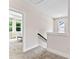 Bright hallway featuring neutral walls, carpet flooring, and a view into an adjacent room with ample natural light at 1645 Carolina Cir, Gastonia, NC 28054