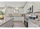 Well-lit kitchen with white cabinets, granite countertops, and modern stainless steel appliances at 1645 Carolina Cir, Gastonia, NC 28054