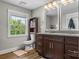 Stylish bathroom with dual sinks, modern cabinetry, and a bright window at 1730 Woodbend Ln, Conover, NC 28613