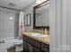 Updated bathroom featuring granite counters, dark cabinetry, stylish decor, and a shower over tub at 1730 Woodbend Ln, Conover, NC 28613