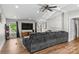 Spacious living room with a large gray sofa, wood floors, TV, and windows with natural light at 1730 Woodbend Ln, Conover, NC 28613
