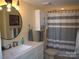 Bathroom featuring a marble vanity, round mirror, and shower/tub with a grey striped curtain at 20417 Harborgate Ct # 510, Cornelius, NC 28031