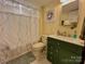 Charming bathroom featuring a green vanity, decorative mirror, and neutral-toned tile flooring at 20417 Harborgate Ct # 510, Cornelius, NC 28031