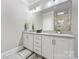 Bright bathroom features a double sink vanity, large mirror, and a glass-enclosed shower at 2108 Bryant Park Dr, Charlotte, NC 28208