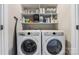 Convenient laundry room with side-by-side washer and dryer and overhead shelving for storage at 2108 Bryant Park Dr, Charlotte, NC 28208