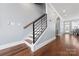 Modern staircase with wood treads and black metal railing leads to the upper level, complemented by wood flooring at 2108 Bryant Park Dr, Charlotte, NC 28208