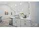 Modern kitchen with white cabinets, stainless steel appliances, and a view into the adjacent dining and living areas at 2116A Glenwood St, Kannapolis, NC 28083