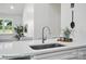 A kitchen island with modern faucet, white cabinets, and view into the dining and living area at 2116A Glenwood St, Kannapolis, NC 28083