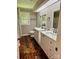A bathroom with and sinks, wood floors, and a window offering natural light at 2130 Vashti Rd, Taylorsville, NC 28681