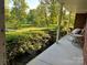 Inviting porch with a wicker chair and view of the well-maintained landscaping and natural surroundings at 2130 Vashti Rd, Taylorsville, NC 28681