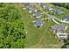 Aerial view of a large home with a sprawling lawn, firepit, and lush green trees, offering privacy at 224 Hidden Meadows Dr, Mooresville, NC 28117