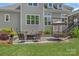 Cozy outdoor living on the stone patio with comfortable seating and an umbrella-covered dining table at 224 Hidden Meadows Dr, Mooresville, NC 28117