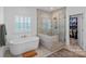 Luxurious bathroom featuring a soaking tub, glass-enclosed shower, and access to a walk-in closet at 224 Hidden Meadows Dr, Mooresville, NC 28117
