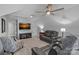 Comfortable bonus room with a large television, reclining sofa, patterned chair, and neutral wall color at 224 Hidden Meadows Dr, Mooresville, NC 28117