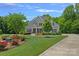 Landscaped front yard with blooming flowers and mature trees frames this beautiful two-story home at 224 Hidden Meadows Dr, Mooresville, NC 28117