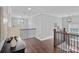Upstairs hallway with wood floors and black metal railing at 224 Hidden Meadows Dr, Mooresville, NC 28117
