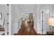 Inviting hallway with hardwood floors leading to a spacious living area with stone fireplace at 224 Hidden Meadows Dr, Mooresville, NC 28117