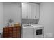Bright laundry room with modern washer and dryer, custom cabinets, and stylish decor at 224 Hidden Meadows Dr, Mooresville, NC 28117