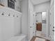 Inviting mudroom with coat hooks, bench, and access to the laundry room featuring modern appliances at 224 Hidden Meadows Dr, Mooresville, NC 28117
