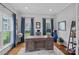Bright home office with a large desk, hardwood floors, and natural light streaming through the windows at 224 Hidden Meadows Dr, Mooresville, NC 28117
